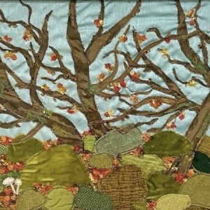 Textile art of a woodland with boulders and an owl, by Jackie Gale, available through Wildwood Art Gallery